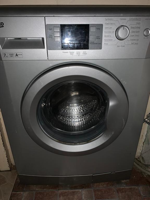 eine silberne Waschmaschine mit einer Schüssel in der Tür in der Unterkunft Beautiful house Perfect Location Lytham St Annes in Saint Annes on the Sea