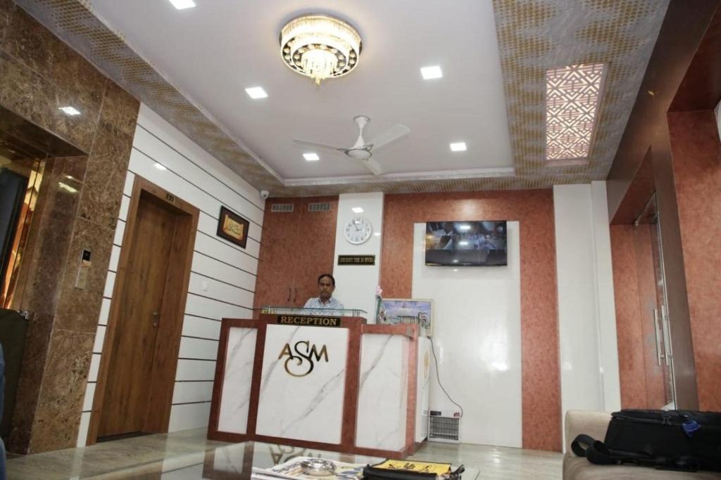 a man standing behind a podium in a room at Hotel Al Sharif Manzil 90 Mtrs from Dargah in Ajmer