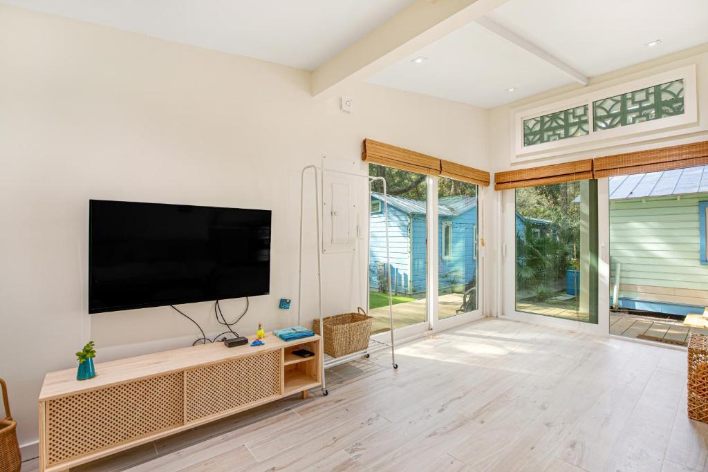 a living room with a flat screen tv on a wall at The Other Place Cottage C in Folly Beach