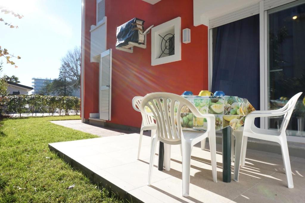 un tavolo e due sedie seduti su un patio di Relax by the garden - flat for up to 6 guests a Porto Santa Margherita di Caorle