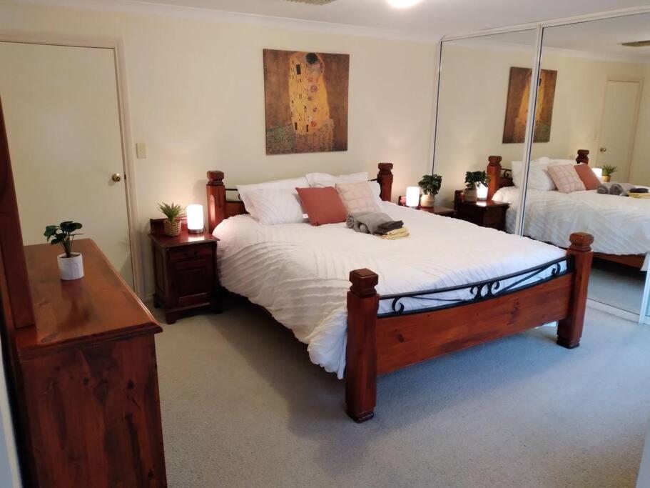 a bedroom with two beds and a mirror at Across the road from the best Pub in Kalgoorlie!!! in Kalgoorlie