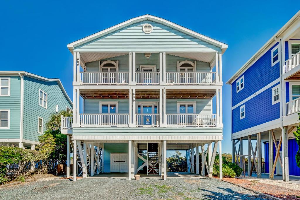 a large blue house with a balcony at Happy Together in Holden Beach