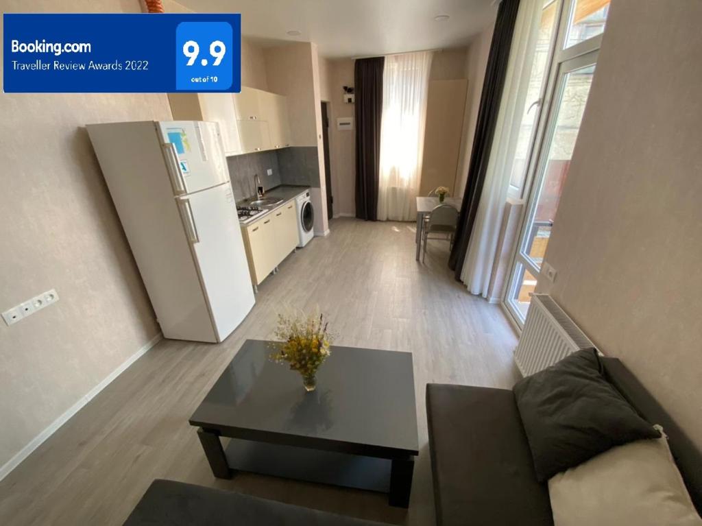 - un salon avec une table et un réfrigérateur dans l'établissement Nikas apartment with balcony in old Tbilisi, à Tbilissi