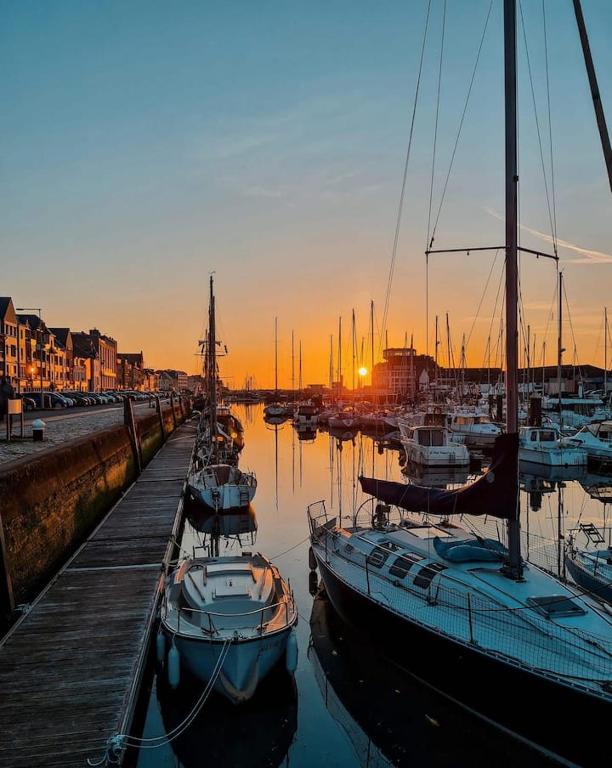 un groupe de bateaux amarrés dans une marina au coucher du soleil dans l'établissement LA PETITE MAISON PRÈS DE LA MER, à Fécamp