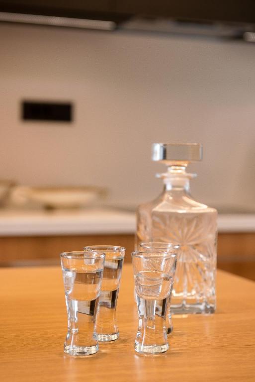 three glasses sitting on a table next to a bottle at Ligaria Mare in Agia Pelagia
