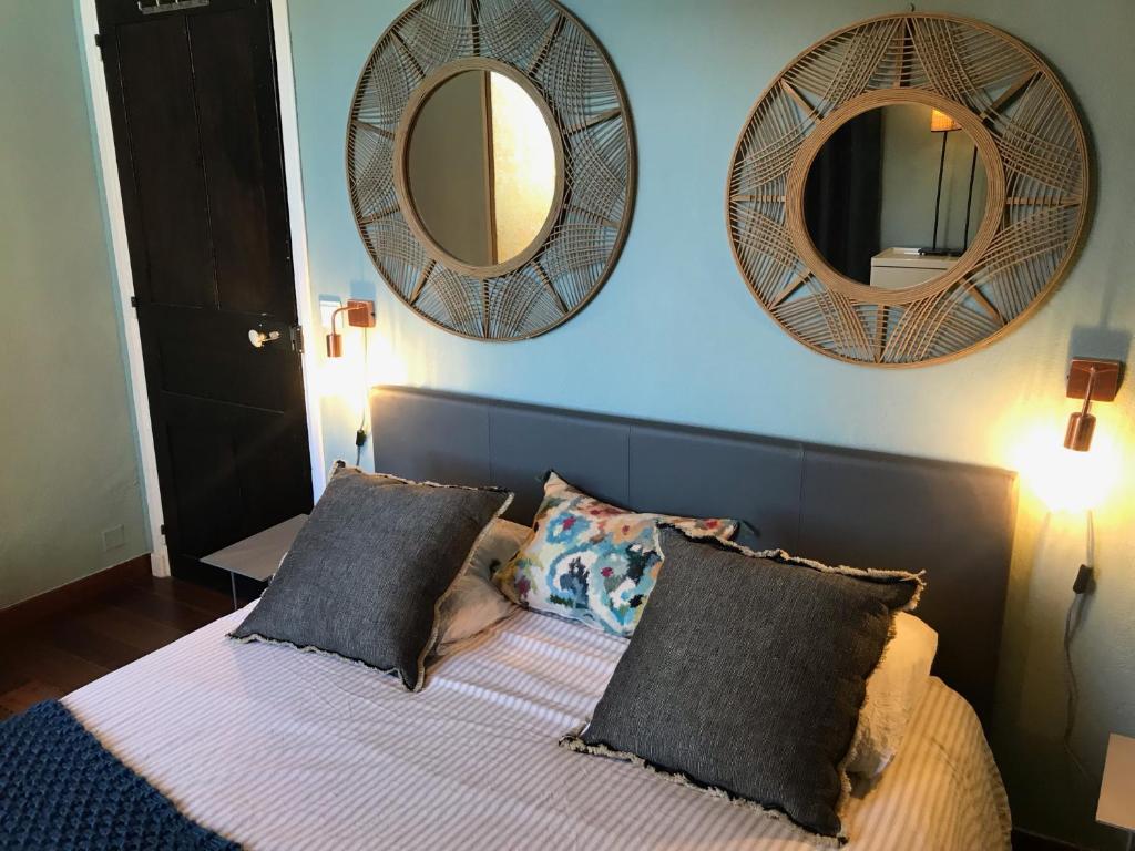 a bedroom with a bed with two mirrors on the wall at Chambre Vinc in Bastia