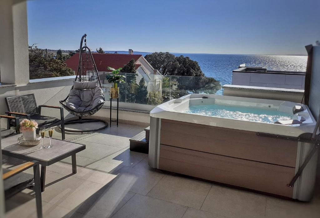 a hot tub on a balcony with a view of the ocean at Penthouse Apartment Perla with Jacuzzi in Novalja