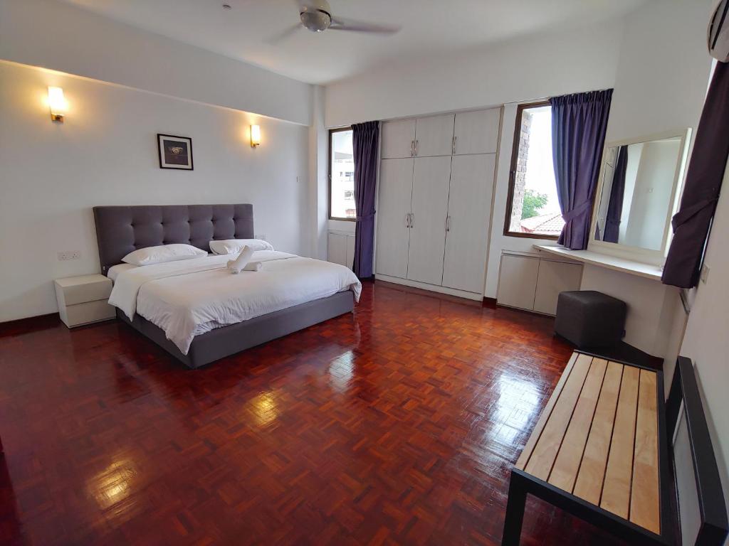 een slaapkamer met een bed en een houten vloer bij GurneyVille in George Town