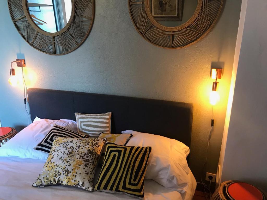1 dormitorio con 1 cama con almohadas y 2 espejos en Chambre Rose en Bastia