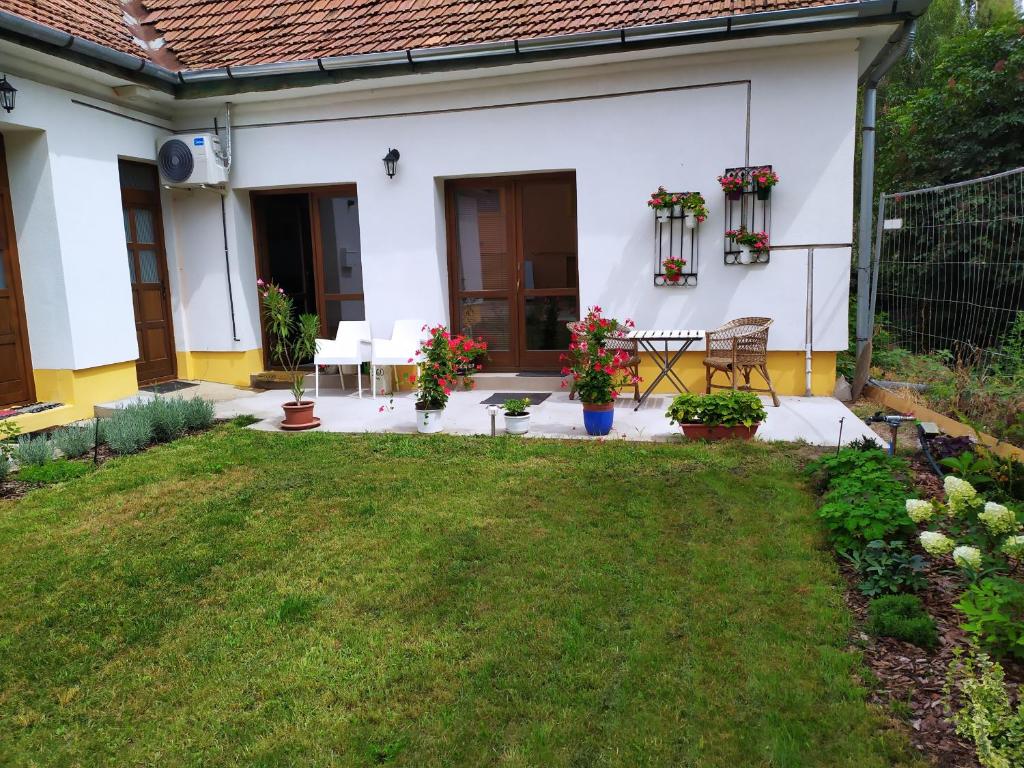 um quintal de uma casa branca com uma mesa e cadeiras em Napraforgó apartman Tokaj em Tokaj