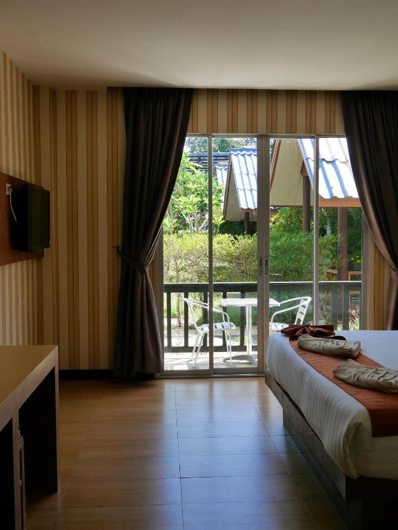 una camera d'albergo con un letto e una porta scorrevole in vetro di Andaman Resort a Phi Phi Don