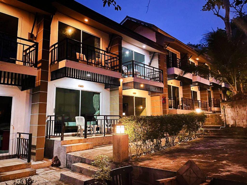 a apartment building with a patio and a table and chairs at PP Midnight Hotel in Phi Phi Don