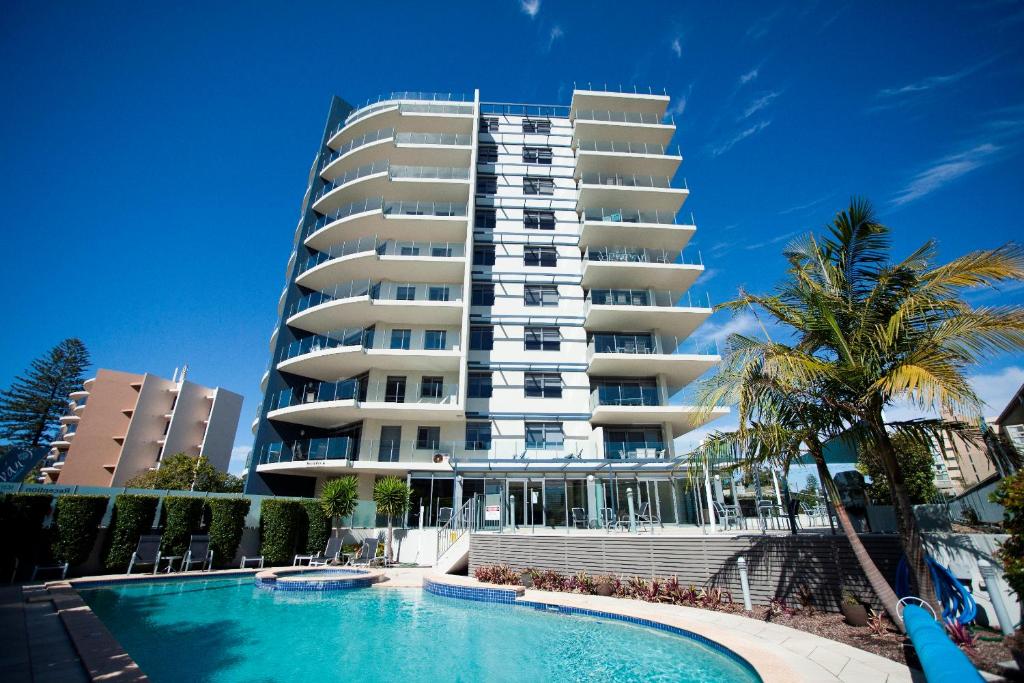 a large apartment building with a swimming pool in front of it at Sevan Apartments Forster in Forster