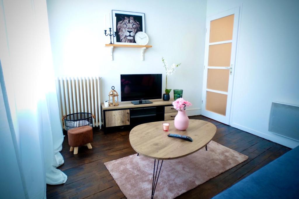 a living room with a table and a tv at Tour Leroy by LCDC in Caen