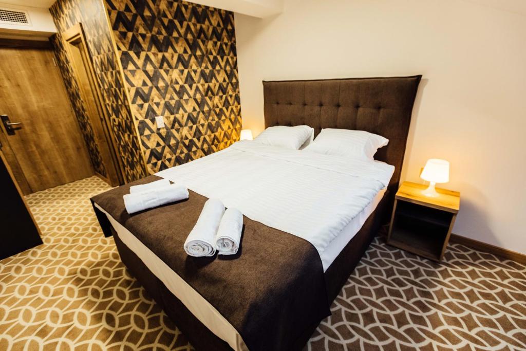 sypialnia z dużym łóżkiem z ręcznikami w obiekcie Hotel Livnica w Belgradzie