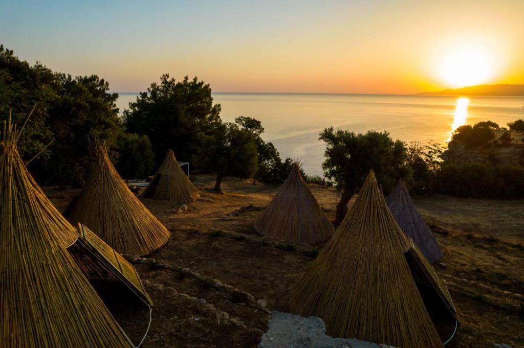 un grupo de tiendas de campaña con la puesta de sol en el fondo en Aphrodite Family Eco Camping, en Neo Chorio