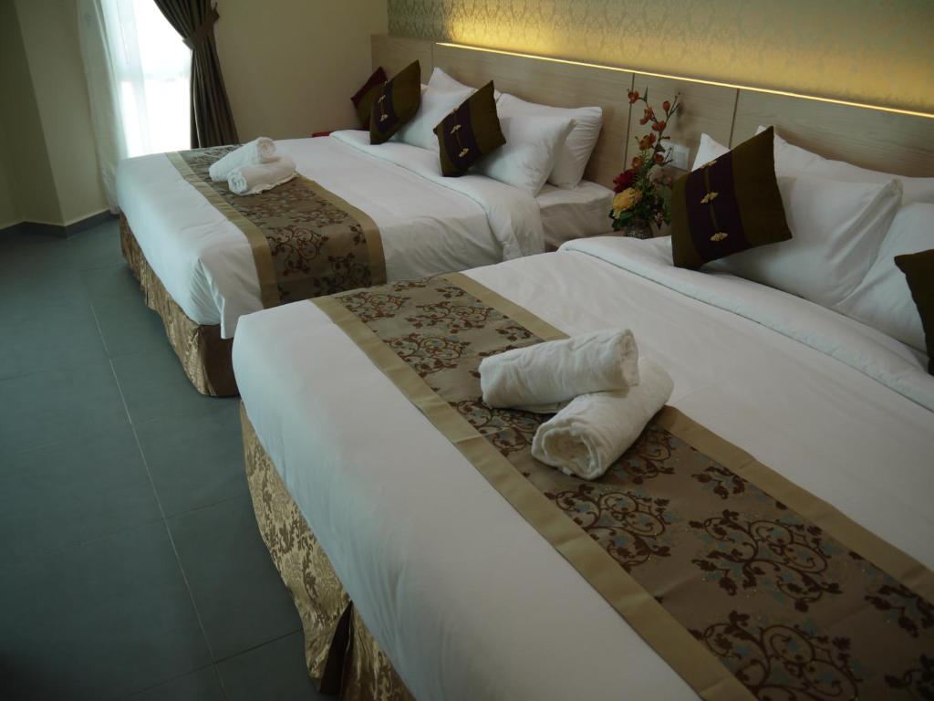 Postel nebo postele na pokoji v ubytování MidCity Hotel Melaka