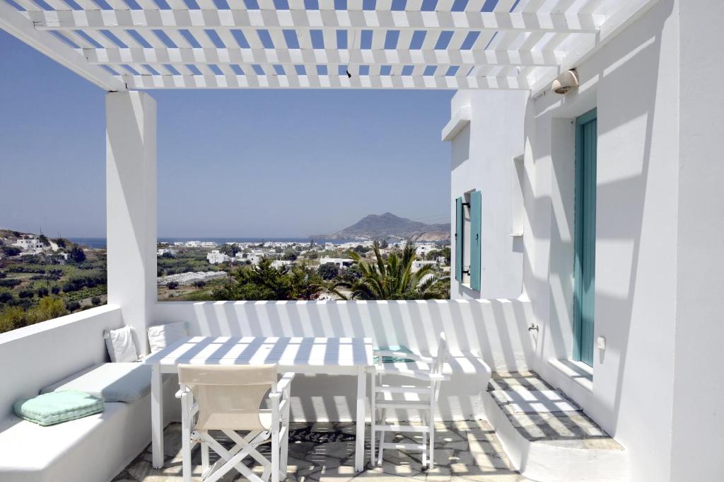 a balcony with white furniture and a table and chairs at Kostantakis Residence & Winery in Pollonia