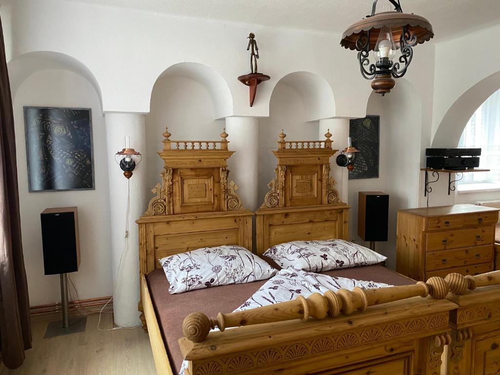 1 dormitorio con cama de madera en una habitación en Penzio Ostrava, en Ostrava