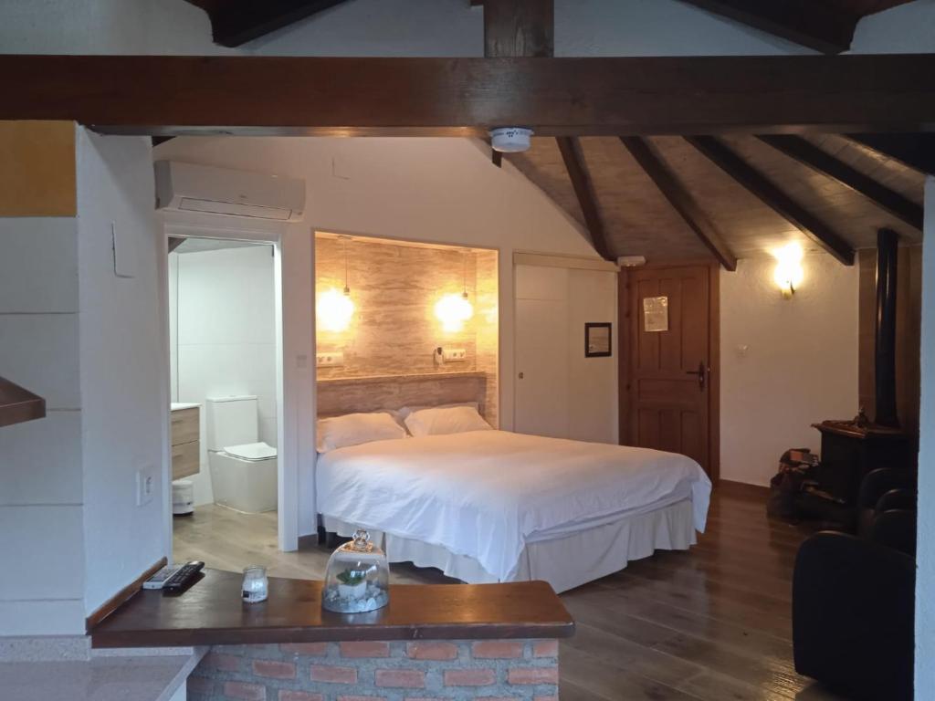 um quarto com uma grande cama branca num quarto em Casa Rural Crisol Spa em Arenas de San Pedro