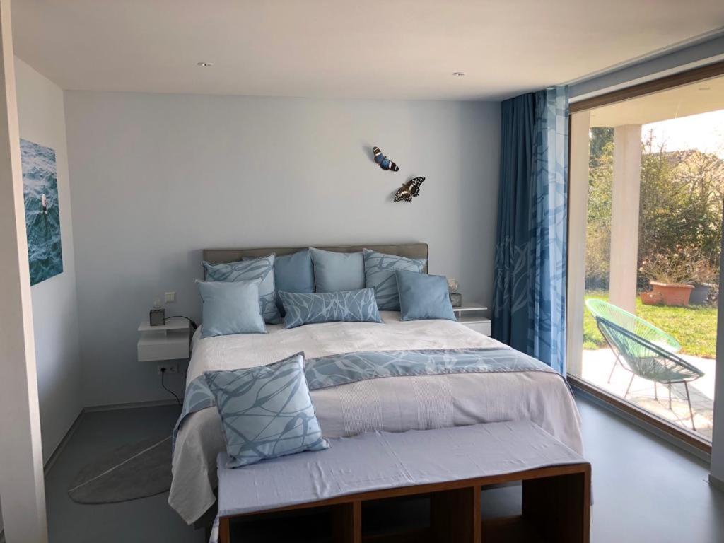 um quarto com uma cama grande e uma janela em SeeSucht-Apartment No86 mit Terrassen, Sauna & Pool em Bodman-Ludwigshafen