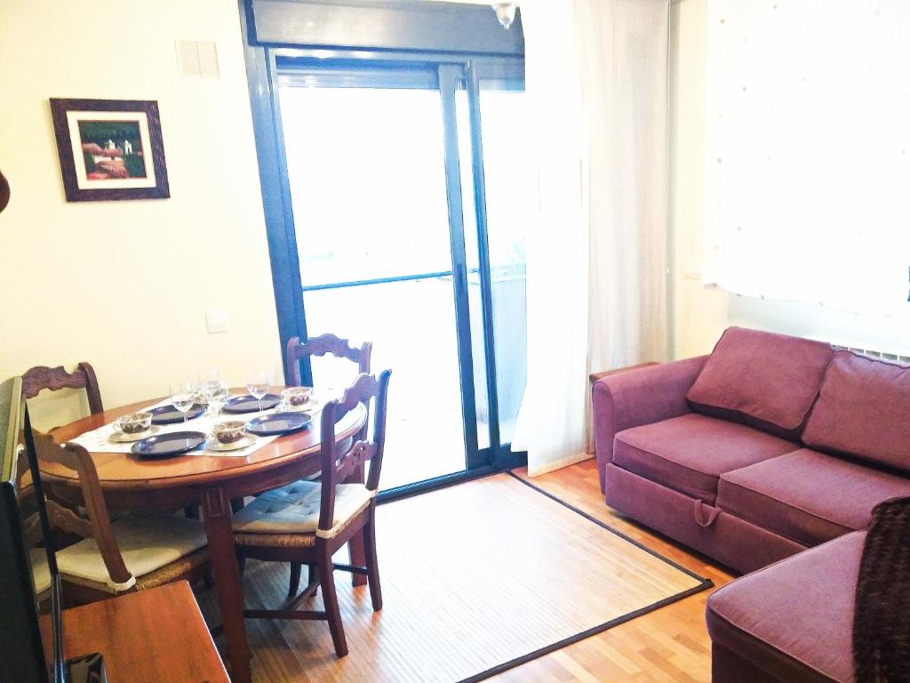 sala de estar con mesa y sofá en LA LUNA DE LUANCO, céntrico, confort y con parking, en Luanco