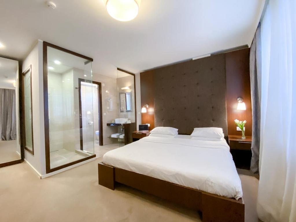 een slaapkamer met een groot bed en een grote spiegel bij Luka de Luka Suites in Belgrado