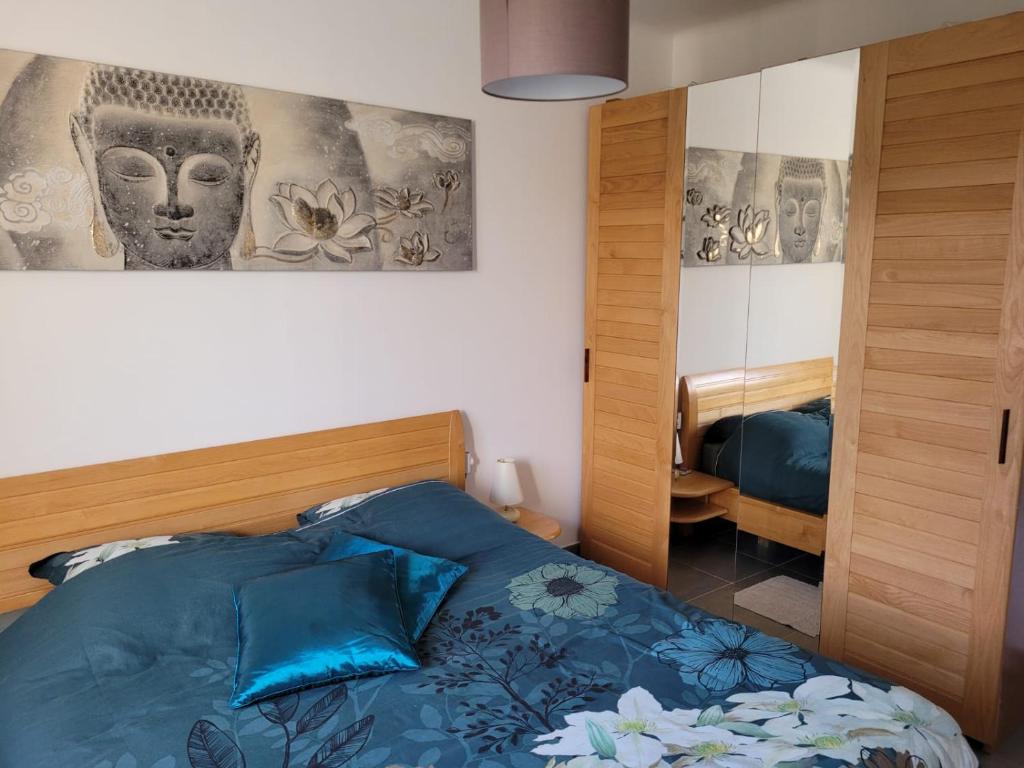 1 dormitorio con 1 cama con sábanas azules y espejo en Welcome en Nantes