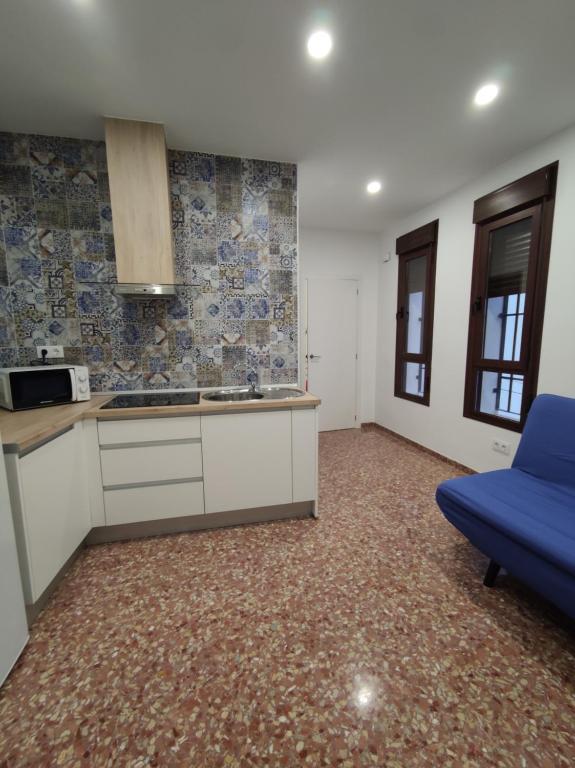 kuchnia z niebieską kanapą w pokoju w obiekcie La Casa de la Mimosa w Kordobie