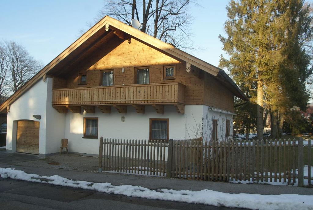 a house with a wooden roof and a fence at Ferienhaus Füchslein in Bayerisch Gmain