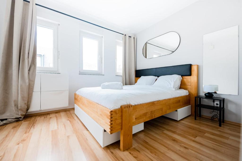 1 dormitorio con 1 cama con paredes blancas y suelo de madera en Business Leisure 1BR Apt Esch-sur-Alzette- ID-56, en Esch-sur-Alzette
