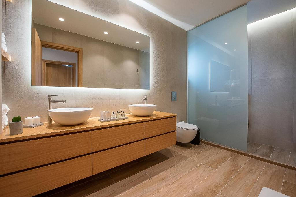 a bathroom with two sinks and a toilet at Ligaria Mare in Agia Pelagia