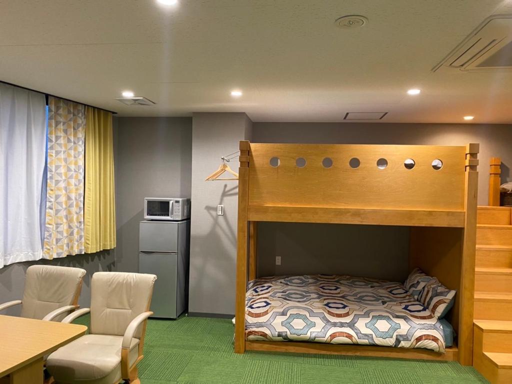 熊本市にあるkdy ｽﾃｲﾊｳｽ 2段ベットの広い客室みんな一緒に泊まれるの二段ベッド1組、テーブル、椅子が備わる客室です。