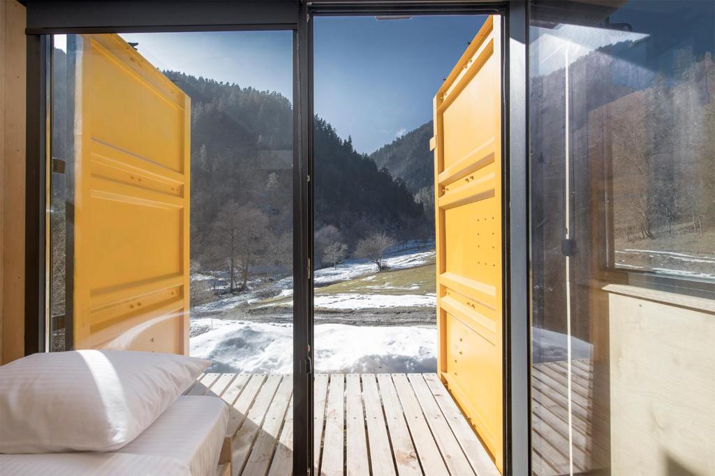a bedroom with a large window with a view at ROOMBOX Likani in Borjomi