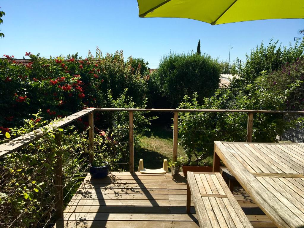 una terraza de madera con mesa y sombrilla en Le Bayanas, en La Rochelle