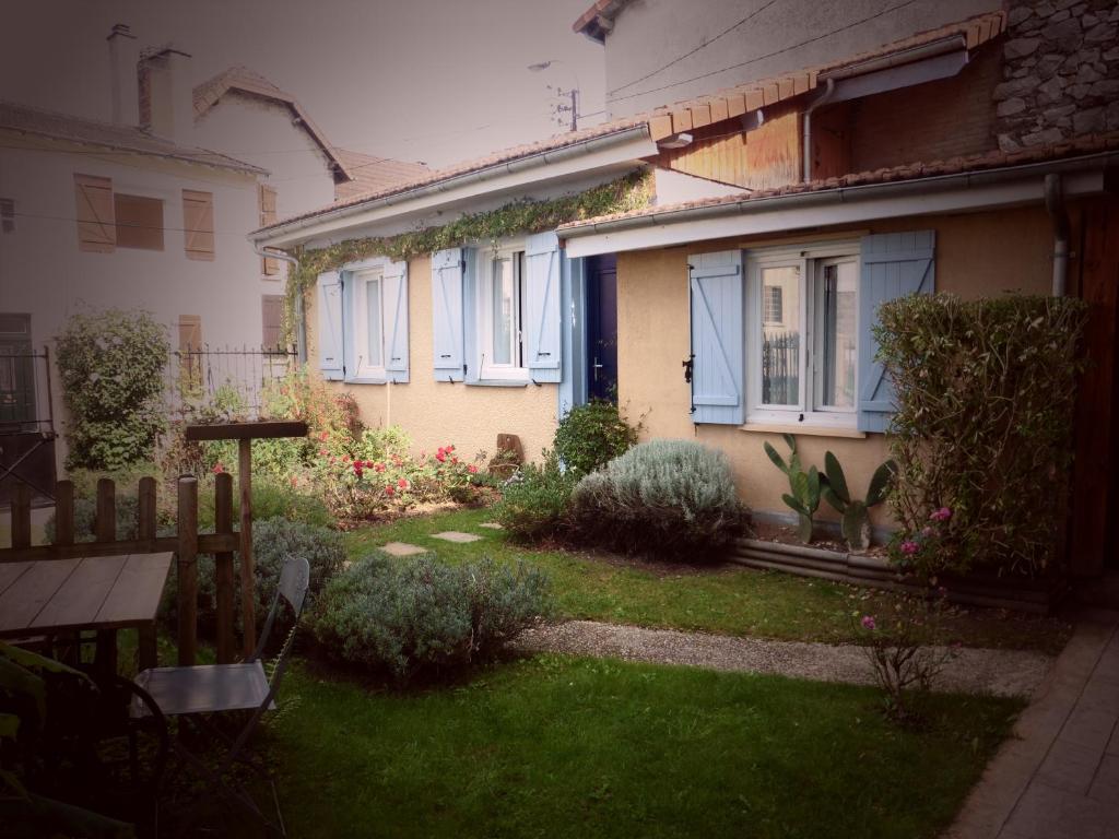 un piccolo cortile con una casa con finestre blu di Chambre d'Hôtes - l'Ephémère a Limoges