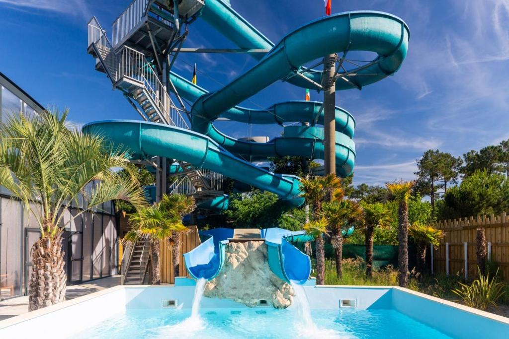 a water slide at a resort with a pool at CAMPING LA PINEDE in Les Mathes