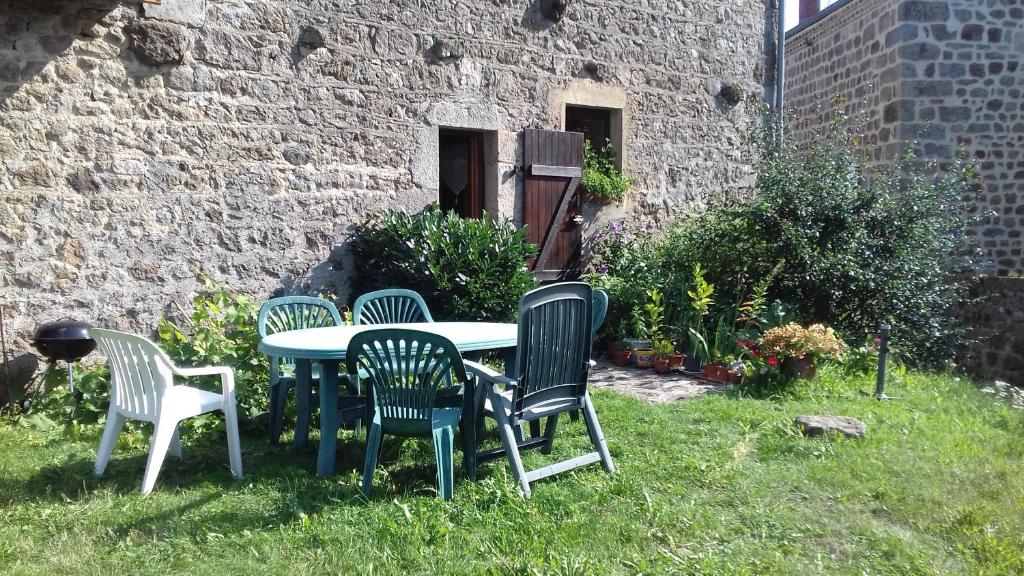 uma mesa e cadeiras num quintal ao lado de um edifício em Chambre d'hôte Saint Pal de Mons em Saint-Pal-de-Mons
