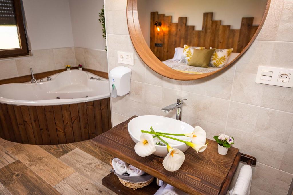 łazienka z umywalką, wanną i lustrem w obiekcie Apartamentos Casa Carin w mieście Cadavedo
