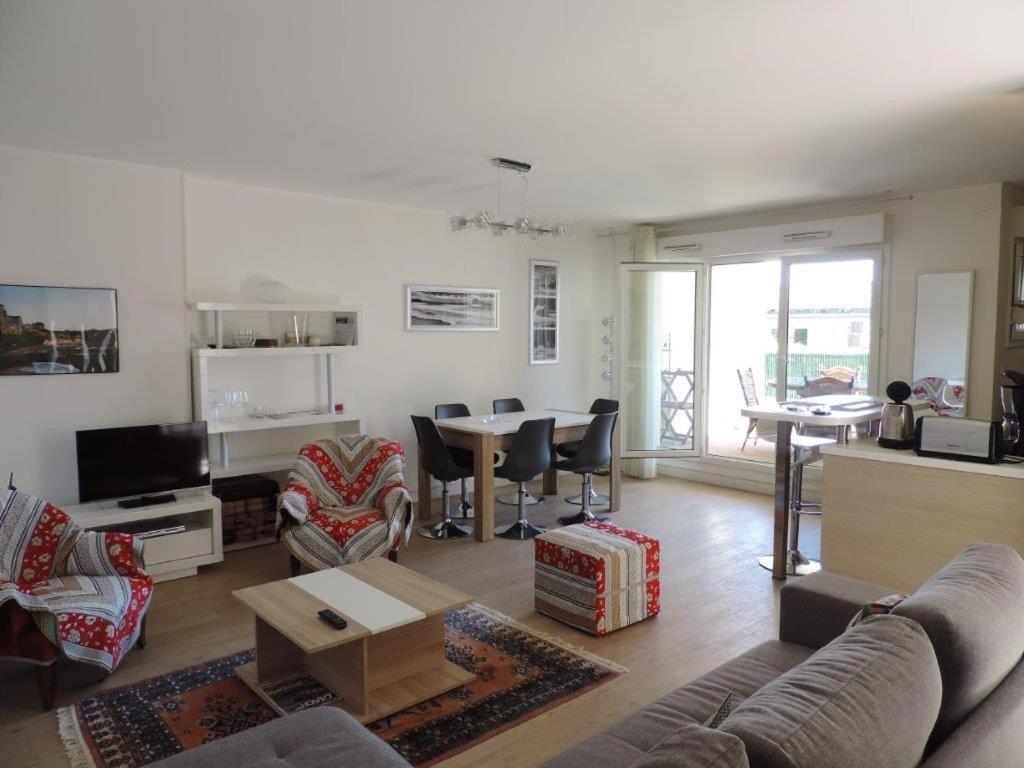 uma sala de estar com um sofá e uma mesa em BIARRITZ T3 CENTRE 4/6 PERS,TERRASSE et PARKING em Biarritz