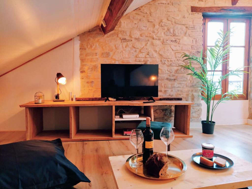 a living room with a tv and a table with wine glasses at Le Chalet d&#39;Amou in Bayonne