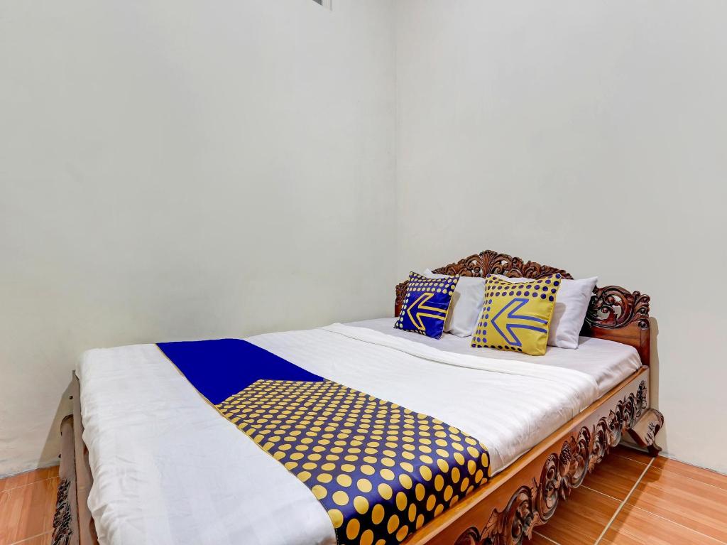 uma cama com almofadas coloridas num quarto em SPOT ON 90744 Alika Homestay em Demak