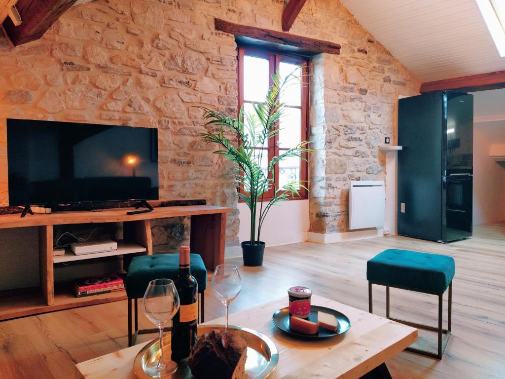 a living room with a table with wine glasses and a tv at Le Chalet d&#39;Amou in Bayonne