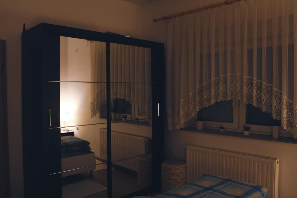 - une chambre avec un lit et une armoire avec un miroir dans l'établissement APARTMENTS KRAPEC, à Ježdovec