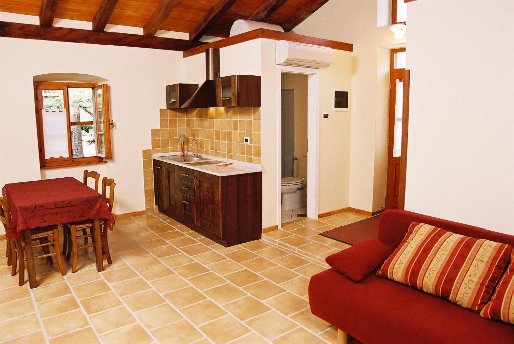 sala de estar con sofá rojo y cocina en Bordon wines, estate with accommodation, en Dekani