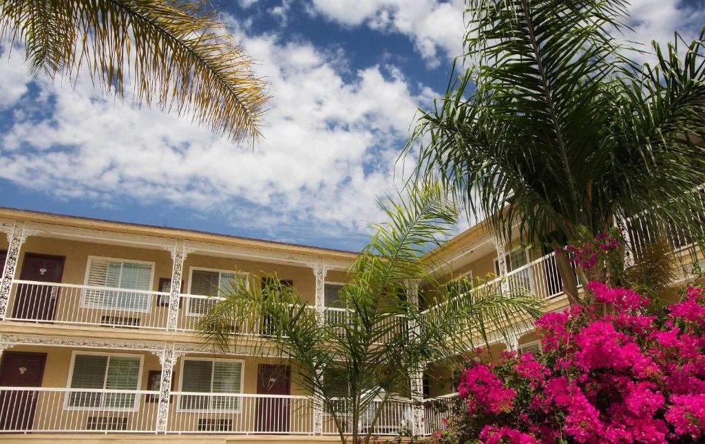 a large building with palm trees and pink flowers at Regency Inn in Los Angeles in Los Angeles