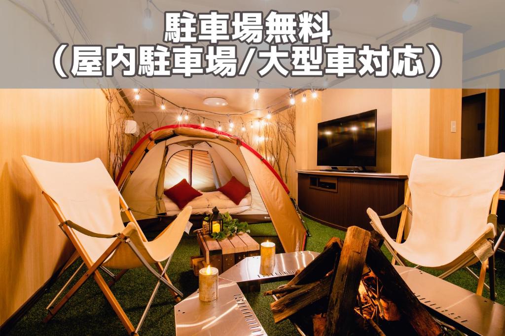 um quarto com uma tenda, 2 cadeiras e uma mesa em A-GATE HOTEL 旭川 -Asahikawa- em Asahikawa