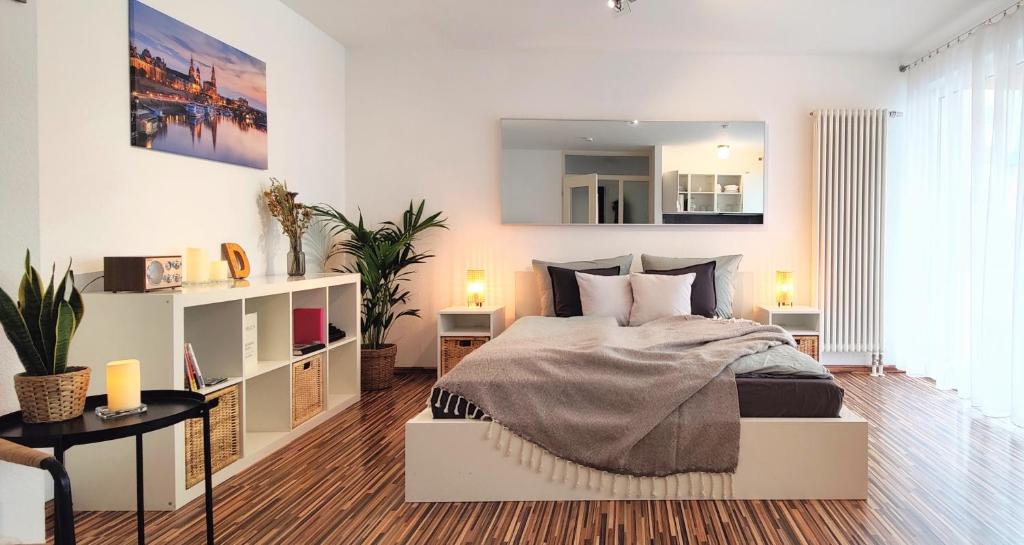 1 dormitorio con 1 cama, 2 mesas y espejo en Gemütliche Ferienwohnung in ruhiger Lage, en Dresden