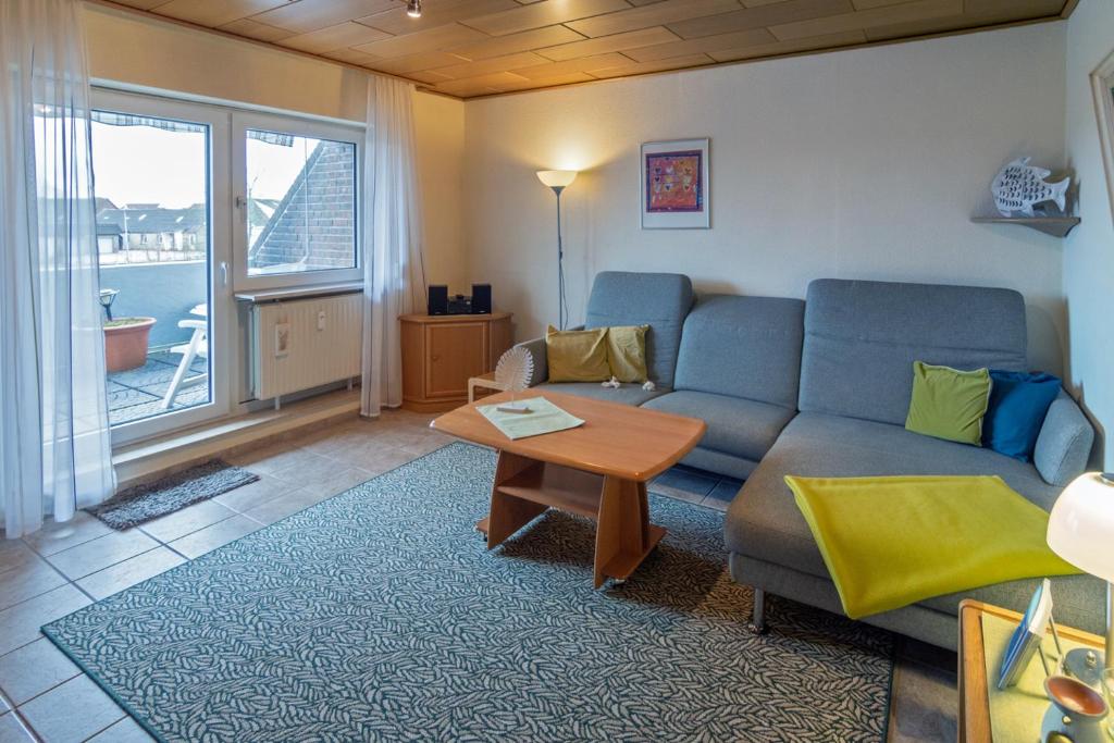 - un salon avec un canapé et une table dans l'établissement Strandflieder, à Dornumersiel