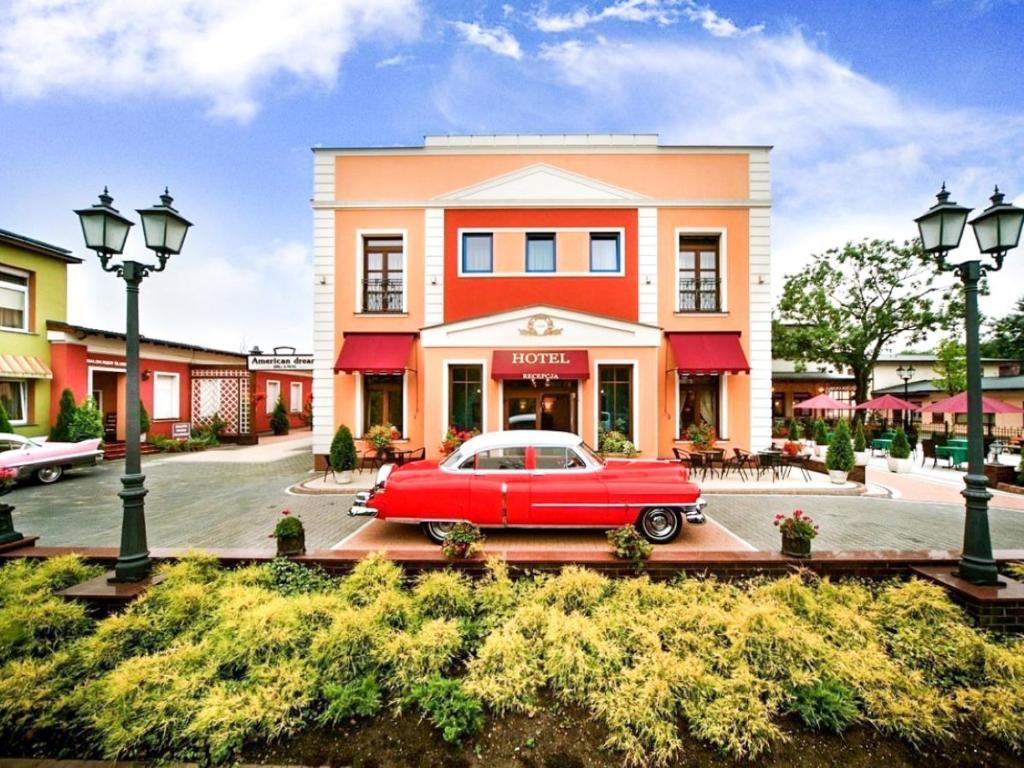 ein rotes Auto, das vor einem Gebäude parkt in der Unterkunft Hotel Stara Garbarnia in Breslau
